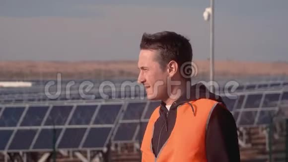 穿着橙色背心的工程师站在企业的场地中间戴上白色头盔和视频的预览图