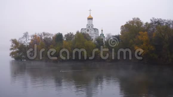 秋日雾蒙蒙的河岸上的东正教教堂视频的预览图