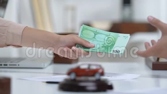 女买家给汽车商欧元握手桌上有汽车玩具视频的预览图
