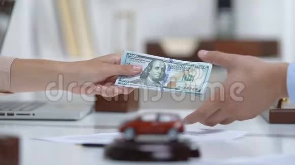 女买家给汽车商人美元握手汽车玩具在桌子上视频的预览图