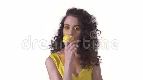 年轻漂亮的卷发女孩手里拿着芬芳新鲜成熟的柠檬愉快地嗅着气味的肖像视频的预览图
