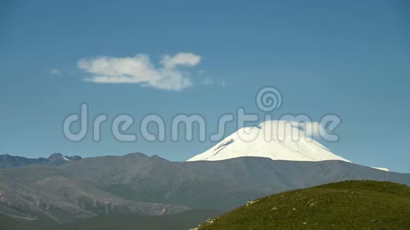 厄尔布鲁斯山东坡的永恒景观在晴朗的蓝天上形成的雪云视频的预览图