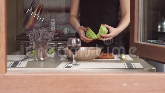 年轻女子在厨房做饭做午餐准备食物休息生菜薰衣草一杯酒穿过视频的预览图