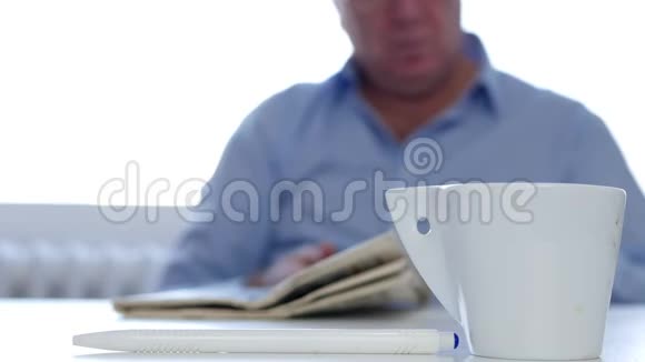放松的商人使用手机饮料咖啡和阅读报纸信息视频的预览图