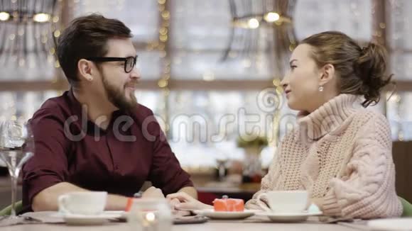 成年男子和妻子坐在餐馆的餐桌旁男人打电话给服务员服务员送花给他们男人送花视频的预览图