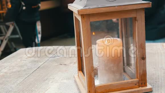 大型蜡烛在一个时尚的木制烛台街道咖啡馆的桌子视频的预览图