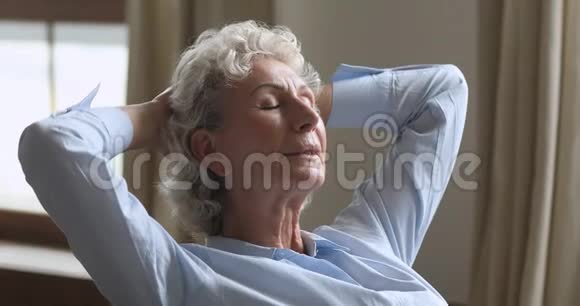 平静的老妇人躺在沙发上享受呼吸新鲜空气视频的预览图