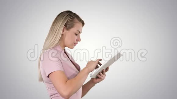 女孩拿着数字平板电脑在梯度背景上搜索一些东西视频的预览图