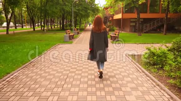 穿灰色外套的女商人在春城玩慢动作视频的预览图