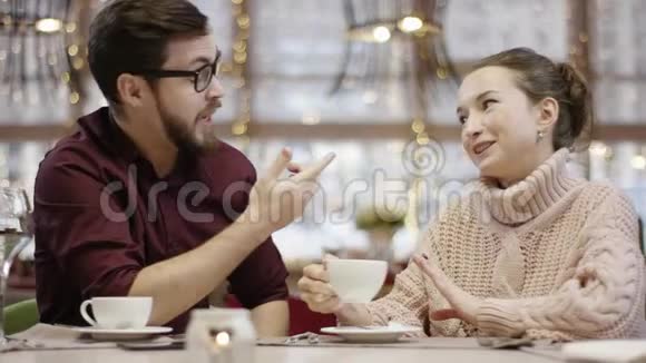 成年男女在喝咖啡的时候一桌一桌地谈论着一些事情一个男人说服她视频的预览图