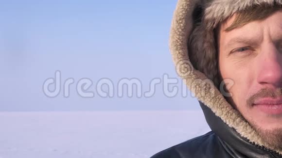 特写一幅中年探险家的半身像在雪域沙漠的背景下平静地看着镜头视频的预览图