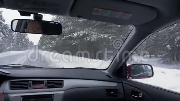 从冬季公路上行驶的后座车上看雪地里开车的女司机视频的预览图