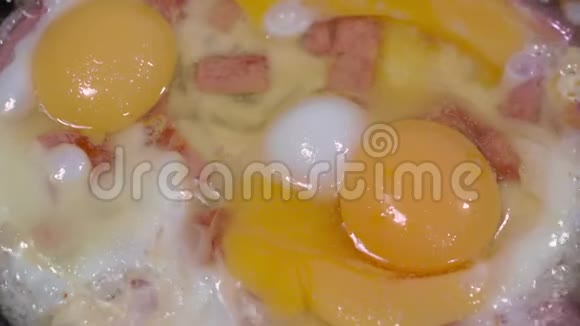 提供煎蛋切片香肠和洋葱炒锅的近景视频的预览图