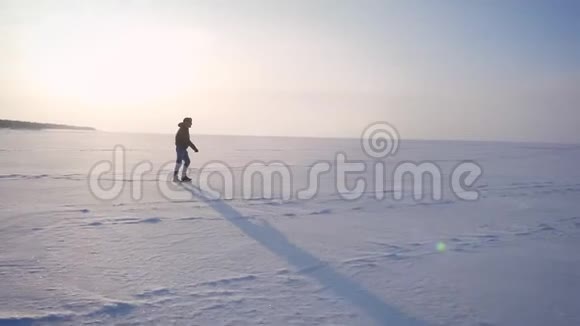 宽放大照片中的快乐男子在雪地上的阳光下向右行走视频的预览图