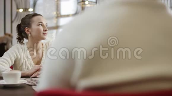 一个年轻的女人正在咖啡馆里从男人手里接过一盒鲜花视频的预览图