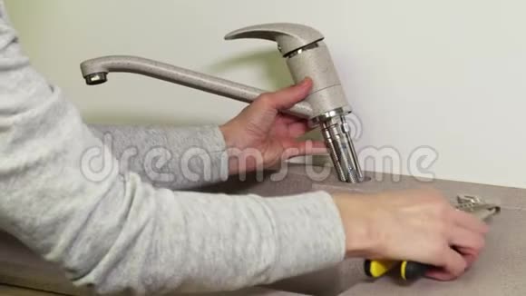 女人在厨房水槽上固定水龙头视频的预览图