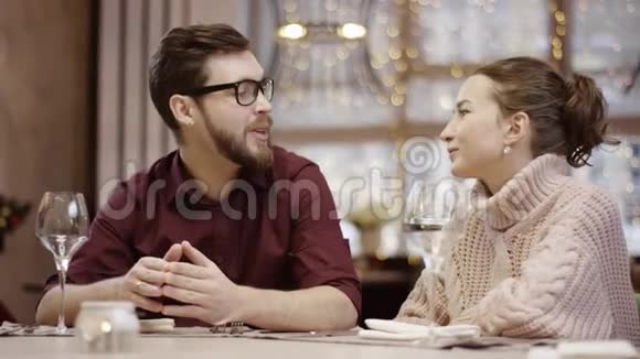 可爱的一对夫妇在餐厅的餐桌旁闲聊视频的预览图