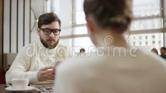 一对成年男女坐在豪华餐厅的桌子旁边用设备聊天视频的预览图