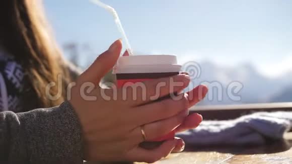 在滑雪胜地的餐厅一个在山顶上喝咖啡的女孩视频的预览图