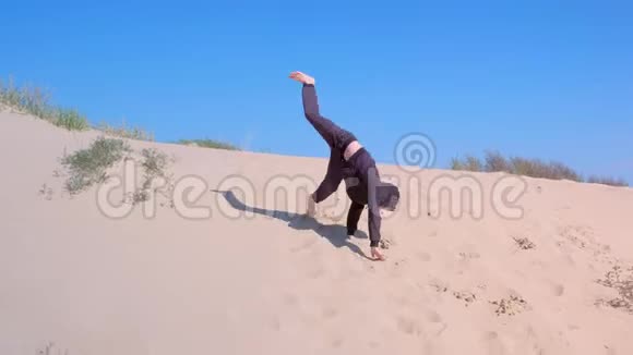 在度假的时候小男孩在海边的沙丘上翻滚视频的预览图