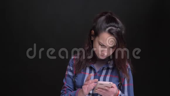 一位年轻美丽的白种人女性的亲密肖像她用电话和社交媒体上的帖子反应过来然后看着视频的预览图