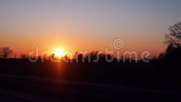 明亮的橙色日落从车窗上看视频的预览图
