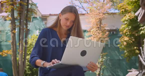 在公园户外使用笔记本电脑的年轻白种人女商人的特写肖像视频的预览图