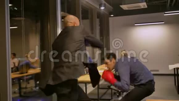 两个在公司办公室打拳击的有竞争力的商人视频的预览图