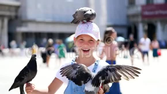 意大利威尼斯2018年7月7日观看快乐的小女孩游客抱鸽子喂食和它们一起玩玩得开心视频的预览图