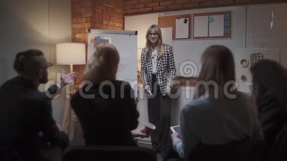 女经理在会议上向同事介绍新的项目计划并向办公室同事解释有关挂图的想法视频的预览图