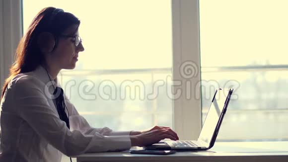 专注专注的女性成功调度员戴着耳机看着屏幕在电脑上工作视频的预览图