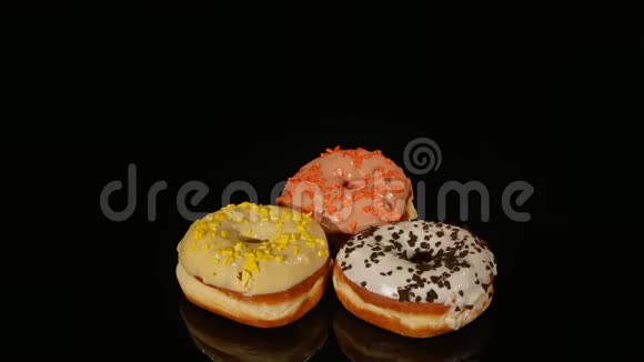 不同填充的釉面甜甜圈在黑色背景上旋转视频的预览图