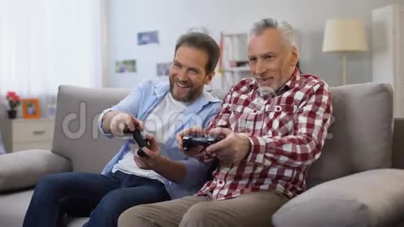 成人父子一起玩电子游戏玩得开心休闲活动视频的预览图