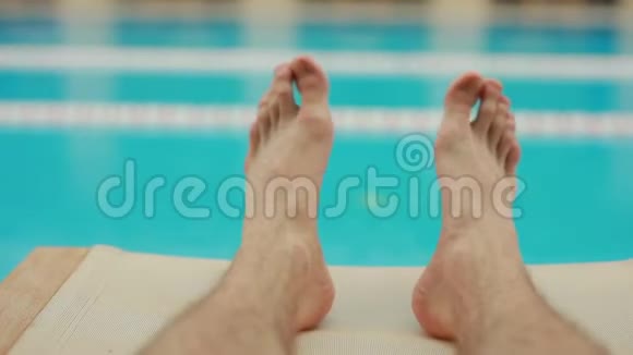 男性腿部在泳池附近放松视频的预览图