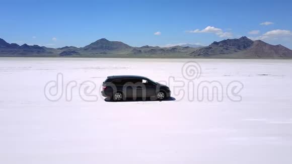 无人机紧随其后离开了银色小型货车沿着犹他州邦纳维尔令人难以置信的盐湖沙漠平原行驶视频的预览图