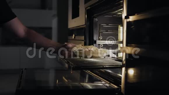 厨师把面包卷和培根和鸡肉放在烤箱里烤在厨房把肉放进烤箱里肉食谱视频的预览图