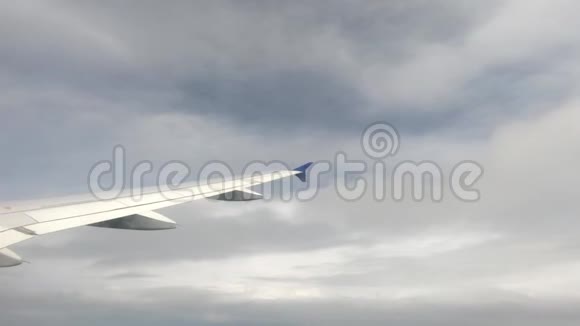 飞机的一个大机翼穿过地面上方厚厚的雨云视频的预览图