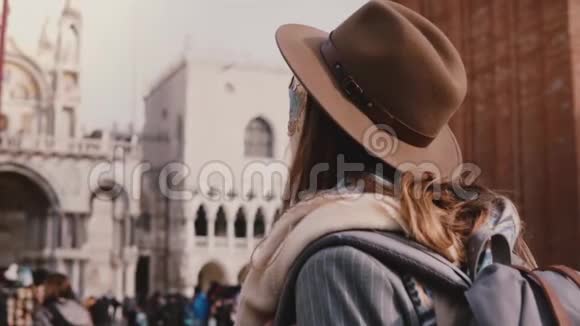在圣马可威尼斯慢动作特写后景拍摄的长发女人戴着时尚的帽子和狂欢节面具视频的预览图