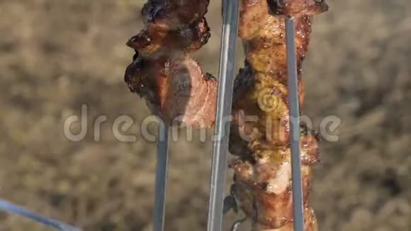 烤架上的一小块新鲜开胃的猪肉用刀子从烤架上切下来放到露天的盘子里视频的预览图