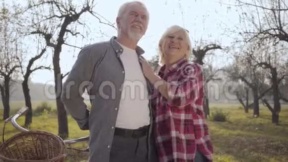 一对快乐的高加索族夫妇站在雾蒙蒙的公园里谈话的肖像微笑着退休的成熟视频的预览图