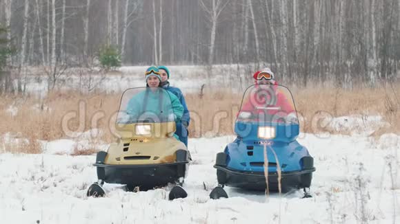冬天一家人穿着五颜六色的夹克坐在雪地摩托上开始骑马视频的预览图