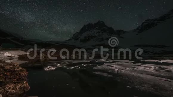白雪皑皑的高山和湖面上带着浮冰的银河的时间推移视频的预览图