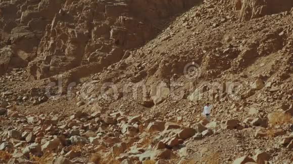 游客在炎热的沙漠中沿着岩石峡谷散步沙漠岩石背景埃及西奈慢动作全高清视频的预览图