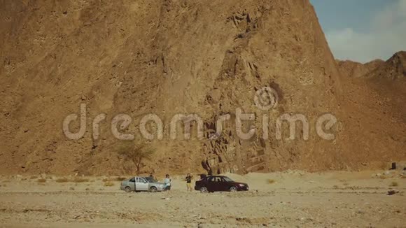 一群游客在炎热的沙漠中沿着岩石峡谷散步沙漠岩石背景埃及西奈慢动作全高清视频的预览图