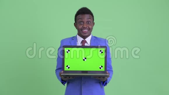 年轻快乐的非洲商人展示笔记本电脑看上去很惊讶视频的预览图