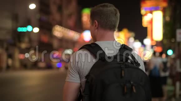 青年游客背包客晚上在唐人街用电话拍照后景视频的预览图
