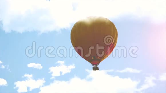 热空气气球在云层和阳光之间的天空中飞行视频的预览图