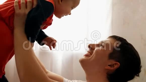 一个年轻快乐的父亲手牵着儿子的手微笑缓慢的动作视频的预览图