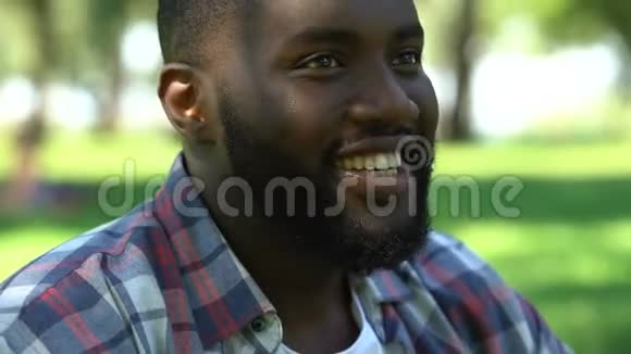 黑人微笑着喝酒在公园里和朋友聚会放松时间视频的预览图