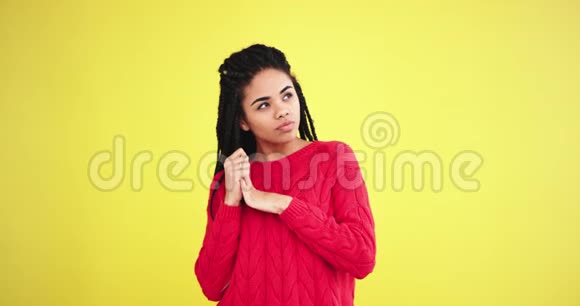 摄影棚里穿着一件红色毛衣镜头前有黄色背景前有黄色背景视频的预览图